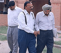 Former Director General of Police, Haryana, Mr S. P. S. Rathore, talking to his counsel in the court complex in Ambala on Saturday.