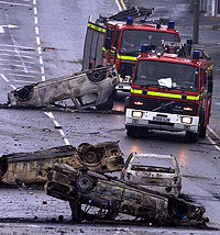 Fire trucks pass burnt-out cars littering the streets of the northern English city of Bradford on Sunday after Asian youths fought police overnight. 