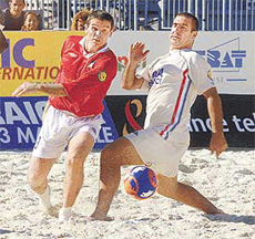 Former French soccer star Eric Cantona (R) fights for the ball against Leon Hunter of England during their match at the European Pro Beach Soccer League in Marseille on Saturday. France defeated England 15-3.