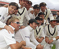 The Australian team celebrates victory over England on the fourth day of the first Ashes Test at Edgbaston, on Sunday. Australia won the match by an innings and 118 runs. 