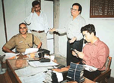 Rajiv Puri and Dayal Massih talk to mediapersons as SP Operations and DSP Special Crime examine the passports seized from them in Chandigarh on Tuesday.