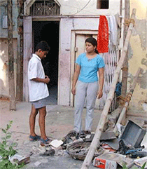 Orphan children Ripu Daman and her brother Zenny Pal standing in front of the portion of their demolished house near Naherwali Haveli in old Delhi area on Wednesday.
