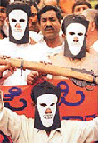 Bharatiya Janata Party (BJP) youth wing activists, brandishing a mock rifle and wearing "death masks" representing Pakistan's intelligence agency, the Inter Services Intelligence (ISI), take part in a peaceful protest in Bangalore on Wednesday. 