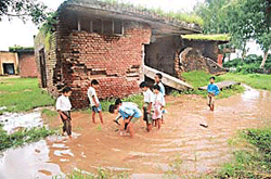 Schoolchildren play near an unsafe building on a school premises at Kansal on Monday. 