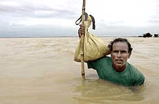 A man wades through flood waters near the village of Bouda Gada