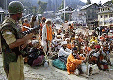 A paramilitary jawan stands guard to Amarnath pilgrims at Srinagar on Sunday morning.