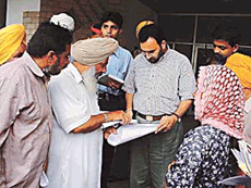 Residents of Thakerwal and Phulewal villages show a road map to the Deputy Commissioner, Mr S.K. Sandhu, in Ludhiana on Thursday.