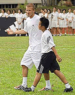 Manchester United star David Beckham gives a pointer to a youth during a short soccer match at a clinic in Singapore on Thursday. 