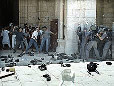 Palestinians hurl shoes as Israeli police storm the Al-Haram Al-Sharif or Temple Mount on Sunday. 