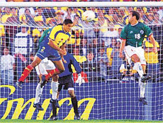 Colombian Ivan Ramiro Cordoba (L) heads the ball into the net on a free kick past Mexican Johan Rodriguez (R) scoring his team's first goal during second half action in the Copa America Championship match in Bogota, Colombia on Sunday. 