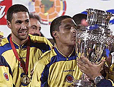 Colombia's defender Mario Yepes (L) watches striker Ivan Cordoba kissing the Copa America trophy after the final in Bogota on Sunday.