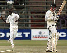 Zimbabwe batsman Andy Blignaut (R) is clean bowled by celebrating West Indies bowler Colin Stuart for 92 runs on Monday.