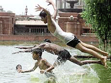 Indian children dive into a pond seeking some respite from the heat in New Delhi on Thursday. 