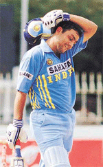 Indian batsman Virender Sehwag wipes his head after completing his century.
