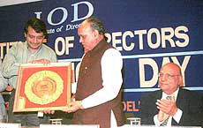Union Power Minister Suresh Prabhu presenting most innovative management award to Himachal Pradesh Chief Minister Prem Kumar Dhumal on foundation day of Institute of Directors in New Delhi on Friday, Lord Swaraj Paul looks on.