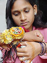 Twelve-year-old Preeti ties a rakhi on the wrist of her brother on the occasion of raksha bandhan in Bhopal, Madhya Pradesh, on Saturday.