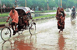 A mother protects her baby during heavy showers in Chandigarh