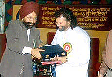 Jasbir Singh Ahluwalia, Vice-Chancellor, Punjabi University, presenting a fellowship award to famous Punjabi Sufi and folk singer Hans Raj Hans in Patiala on Tuesday.