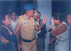 Tibetan women express their fear and anger to a police officer.