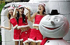 Clad in Santa Claus costume for summer use, South Korean models dance next to a snowman and a snow hut made of styrene foam to entertain customers in the heat of summer outside a department store in Seoul on Friday.