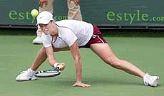 Kim Clijsters of Belgium returns a shot to Alicia Molik of Australia on Thursday