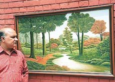 Ajay Sohi with one of his paintings in Chandigarh.