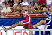 Felix Sanchez of the Domincan Republic (L) jumps the final hurdle.