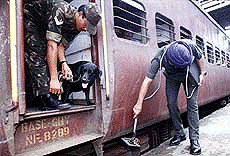 Army jawans checking a train with sniffer dog.