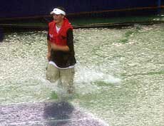 A ball boy runs across the centre court.