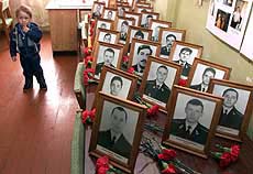 A Russian boy stands by portraits of Kursk submarine victims in their barracks during a memorial ceremony in the Russian Arctic port of Vidyayevo on Sunday.