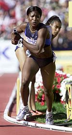 Suziann Reid ( L) of the USA runs with the baton upon retrieving it after it was dropped on the hand off from teammate Michelle Collins( R) during the women's 4x400 meter final at the World Championships in athletics in Edmonton on Sunday.