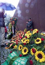 People stand in front of wreaths at the wall memorial at Bemauer Strasse on Monday after an official ceremony to mark the 40th anniversary of the Berlin Wall's construction. 