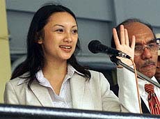 Ardhia Pramesti Regita Cahyani known as "Tata", wife of fugitive Hutomo "Tommy" Mandala Putra, waves to photographers 