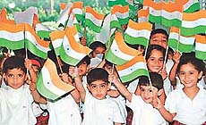 Children of Strawberry Fields School wave flags that they made on the eve of the Independence Day, in Sector 24, Chandigarh, on Tuesday.