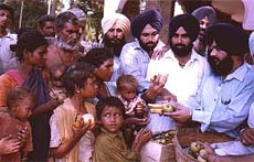 SAD leader Ranjit Singh Nikra distributing fruit.
