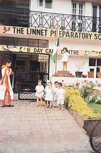 A proud two-and-a-half-year-old child of Linnet Preparatory School and Day Care Centre hoists the National Flag.