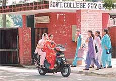 Girls zip out of their college without paying heed to the Principals’ advice to wear helmets.