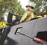 A paramilitary jawan atop an APC