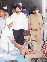 An ITBP doctor examines a patient during a camp organised on the eve of the Independence Day at Shatabgarh village.