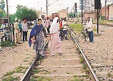 People cross the railway track near Dukhnivaran Gurdwara, risking their lives. 