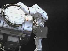 Astronauts prepare to attach an experiment.