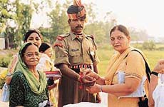 Members of the Roopika Ladies Club tie raakhi on the wrist of a jawan at the Wagah border