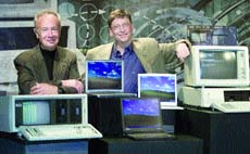 Bill Gates (R), chairman and chief software architect of Microsoft, stand with two of the oldest computers on each end and three of the newest laptop computers in the centre.