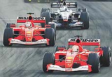 German Ferrari driver Michael Schumacher leads the race ahead of his team-mate Rubens Barichello (L) followed by British McLaren Mercedes driver David Coulthard (back) at the start at the Hungaroring racetrack near Budapest on Sunday.