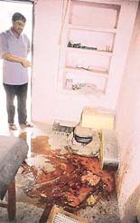 Rakesh Kumar, manager of the petrol station, points towards the pool of blood in a room.