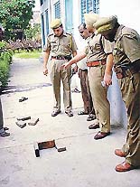 Policemen examine footprints of the assailants.