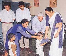 Ms Kamla Sharma, Chairperson, Chandigarh Social Welfare Advisory Board, distributes uniforms among children of the day-care centre being run by Durga Das Foundation at Dhanas village on Tuesday.