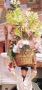 A vendor carries baskets of flowers down a street in Jaipur on Wednesday as India celebrates "Ganesh Chaturthi".