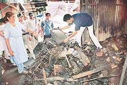 A shopkeeper salvages usuable items out of the remains of a shop gutted in Phase 3B1 of SAS Nagar in the early hours of Wednesday.