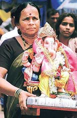 A woman carries an idol of Ganesha
